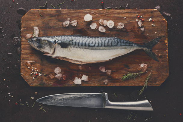 Fresh mackerel on wooden board at black background - Foto, Bild
