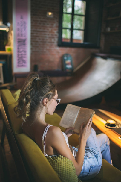 Young pretty caucasian woman reading book in cafe wearing eyegla - Photo, Image