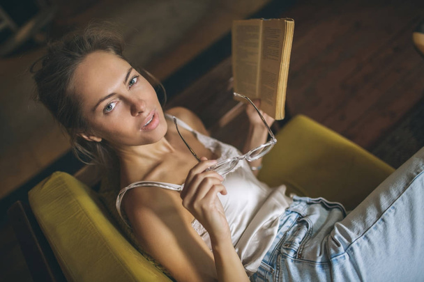 Young pretty caucasian woman reading book in cafe wearing eyegla - Fotoğraf, Görsel