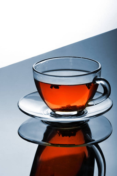 Cup of tea with plate on the reflective surface.Creative reflection.Gradient background.Copy space - Valokuva, kuva