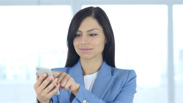 Woman Using Smartphone at Work for Browsing - Foto, imagen
