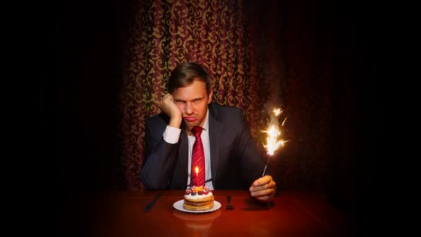 un homme seul célèbre des vacances, il s'assoit seul à une table avec un gâteau et une bougie. 4k, au ralenti
 - Séquence, vidéo