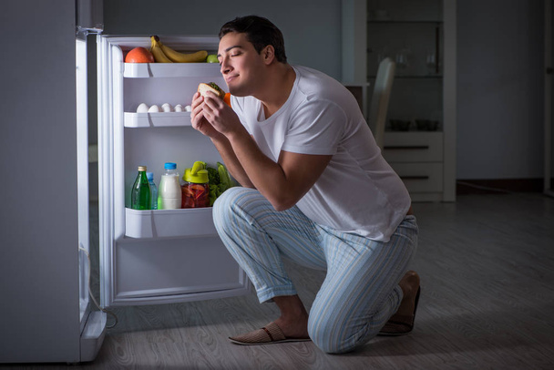 Чоловік в холодильнику їсть вночі
 - Фото, зображення