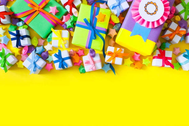 Colored gift boxes with colorful ribbons. Yellow background. Gif - Fotó, kép