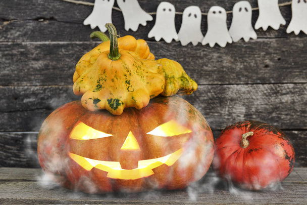 Ahşap zemin üzerine sis hayaletlere çevrili spooky Halloween balkabağı kafa jack fener - Fotoğraf, Görsel