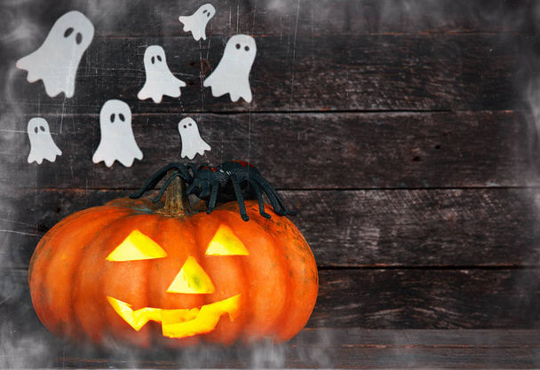 Spooky Halloween pumpkin head jack lantern surrounded by ghosts in the fog on wooden background - Φωτογραφία, εικόνα