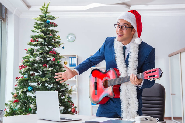 Businessman celebrating christmas holiday in the office - Photo, Image