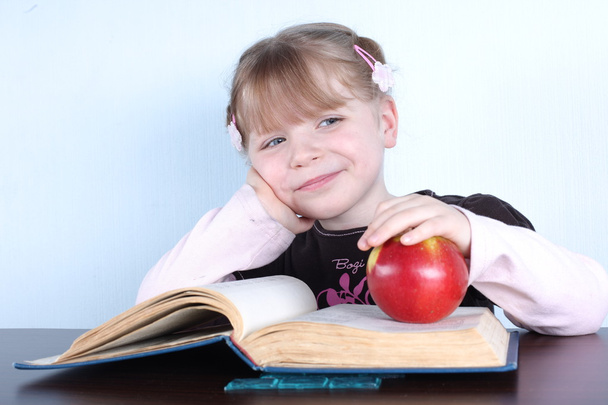 Little girl with apple and books - Фото, зображення