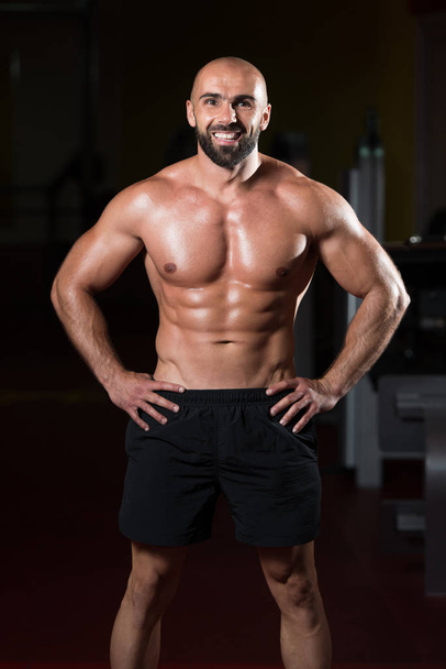 Handsome Muscular Man Flexing Muscles In Gym - Foto, imagen