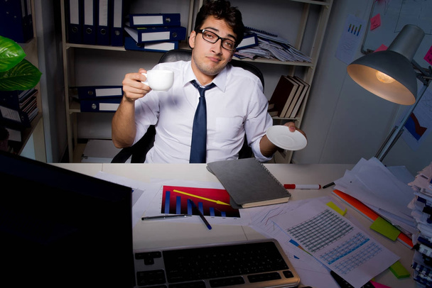 Бизнесмен работает допоздна в офисе - Фото, изображение