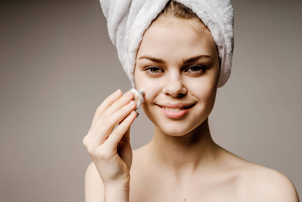 hermosa chica sonriente después de una ducha se frota la cara con una esponja
 - Foto, imagen