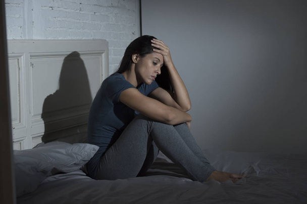 hermosa mujer latina triste y deprimida sentada en la cama en casa frustrado sufrimiento depresión
  - Foto, imagen