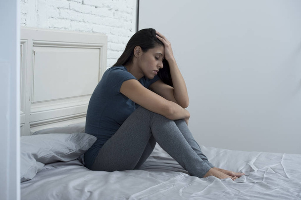 bella donna latina triste e depresso seduto sul letto a casa frustrata sofferenza depressione
  - Foto, immagini