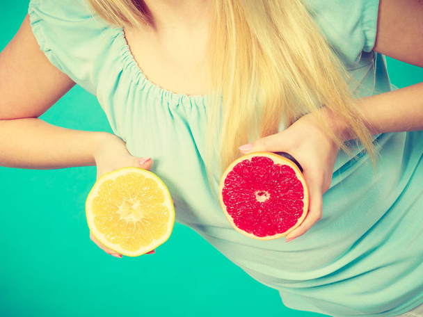 Woman holding red and green grapefruit - 写真・画像