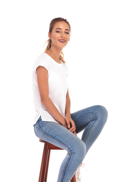jovem mulher casual está rindo enquanto sentado em uma cadeira
  - Foto, Imagem