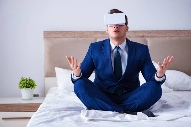 Businessman wearing a virtual reality headset in the bedroom - Foto, Imagem