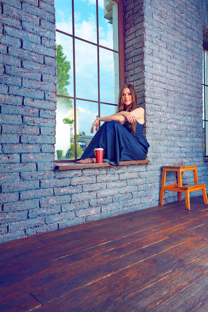 Woman sitting on windowsill. Coffee break.  - Фото, зображення