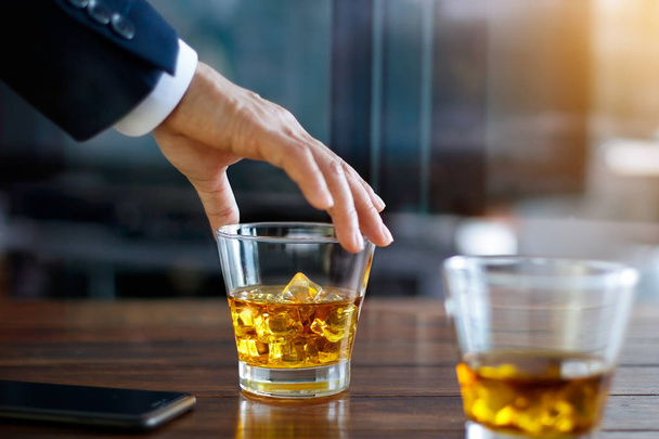 バーボン ウイスキーのガラスに触れては実業家の手 - 写真・画像