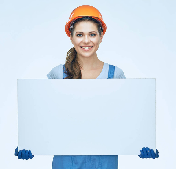 Smiling woman builder holding white baneer.  - 写真・画像