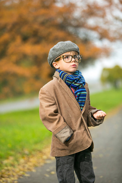 Cute stylish boy in warm clothes in autumn scenery - Foto, afbeelding