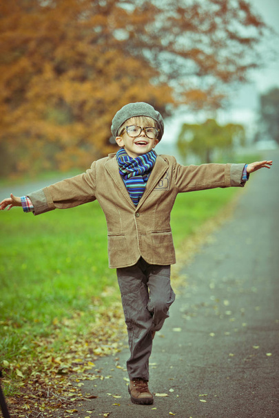 Cute stylish boy in warm clothes in autumn scenery - Foto, Bild