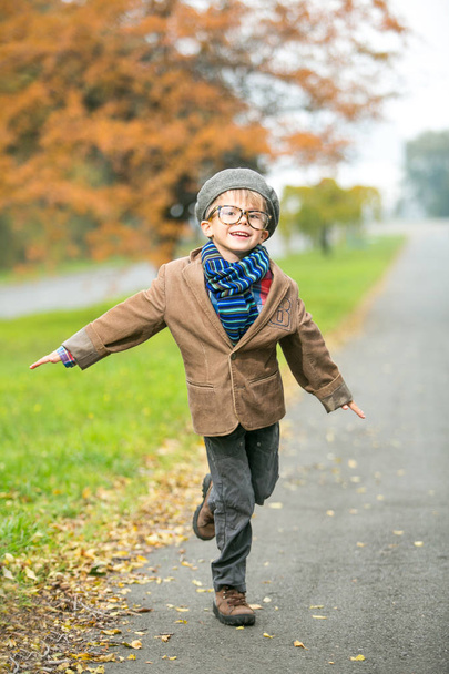 Cute stylish boy in warm clothes in autumn scenery - Foto, Imagen