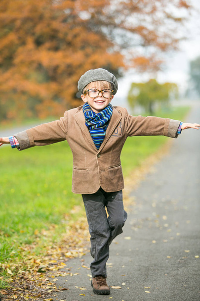 Cute stylish boy in warm clothes in autumn scenery - Fotoğraf, Görsel