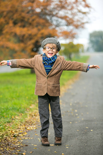Cute stylish boy in warm clothes in autumn scenery - Zdjęcie, obraz