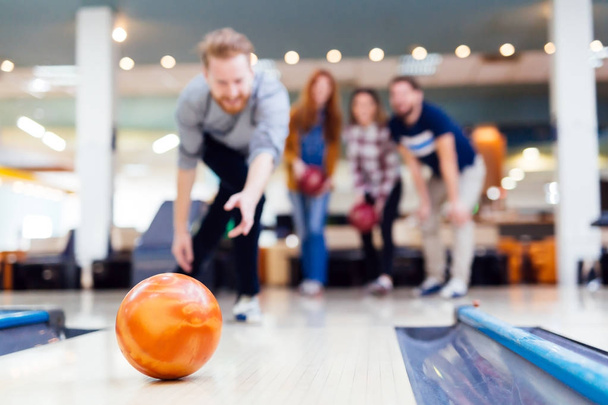 Friends having fun while bowling - Фото, изображение
