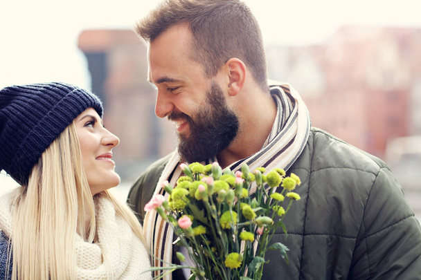 Photo montrant un jeune couple avec des fleurs datant de la ville
 - Photo, image