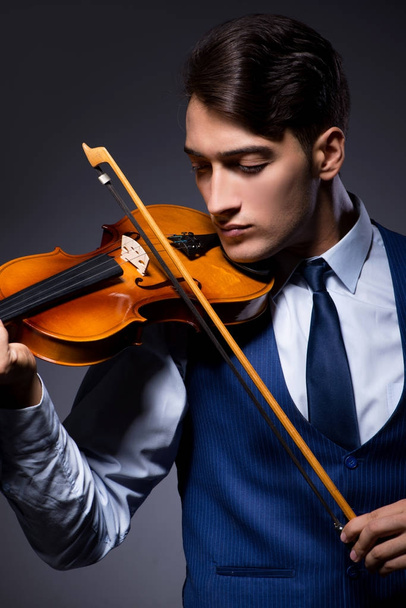 Young man playing violin in dark room - Photo, Image