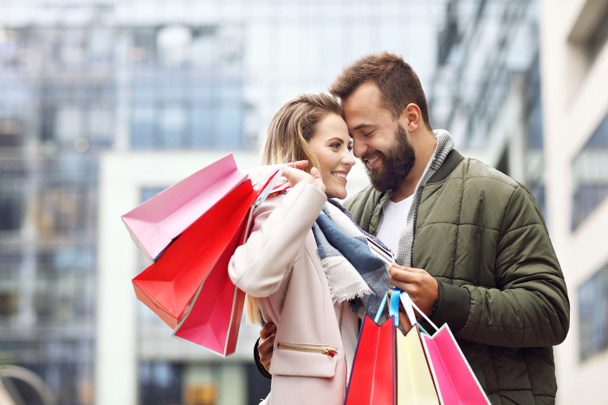 Счастливая пара делает покупки в городе
 - Фото, изображение