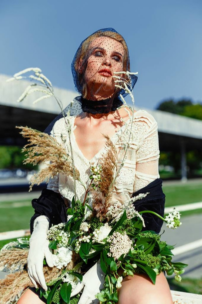woman holding bunch of wildflowers - Fotoğraf, Görsel
