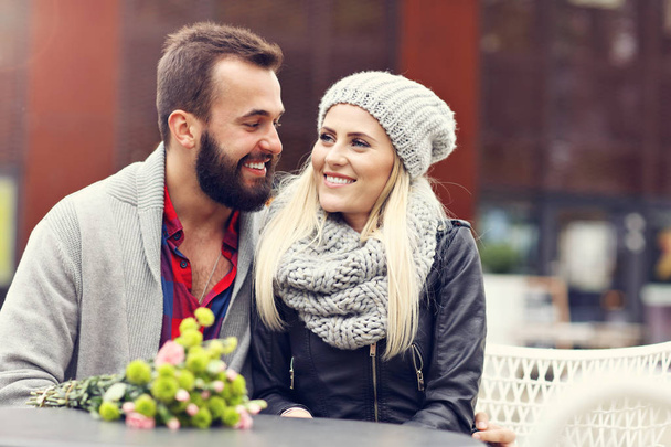 Obrázek ukazuje mladý pár s květinami randění ve městě - Fotografie, Obrázek
