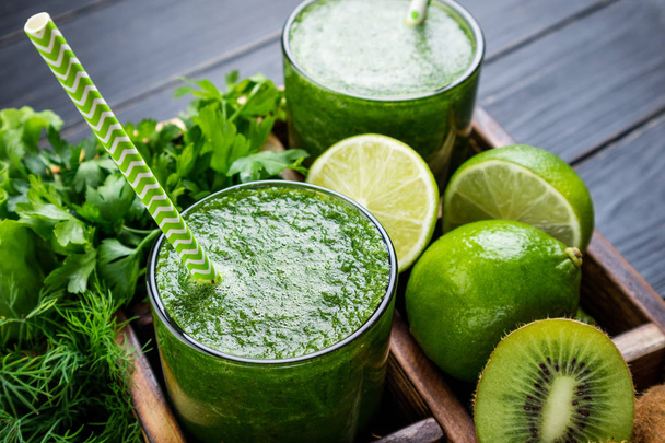 Green smoothie with vegetables, fruits and herbs. Healthy smoothie with spinach, lime, kiwi and herbs. Healthy drink and eating concept - Photo, Image