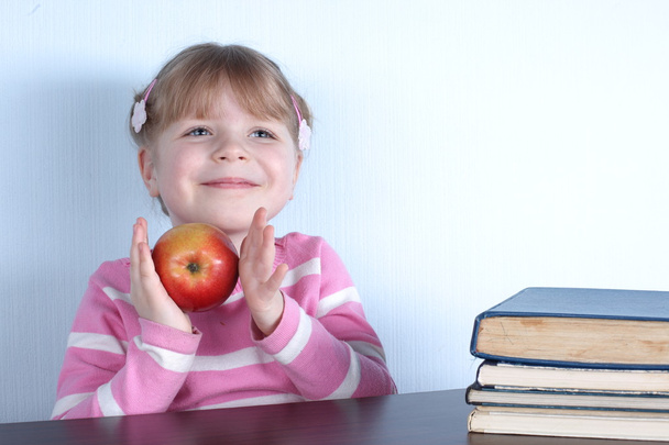 Little girl with apple and books - Foto, Imagen