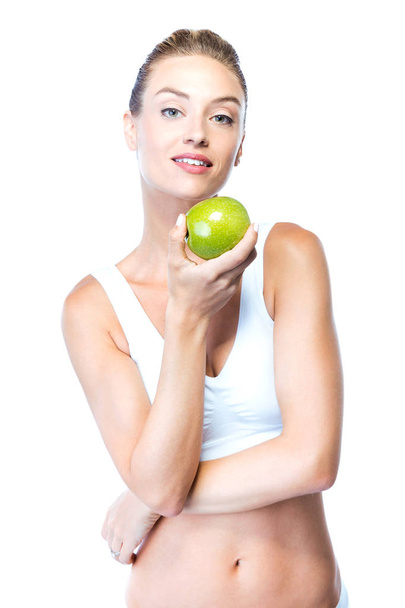 Beautiful young woman eating an apple over white background. - Φωτογραφία, εικόνα