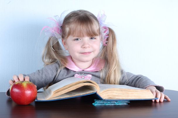 Bambina con mela e libri
 - Foto, immagini