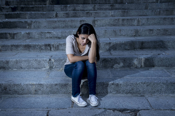 mooi en triest Hispanic vrouw wanhopig en depressief zittend op stedelijke stad straat trap - Foto, afbeelding