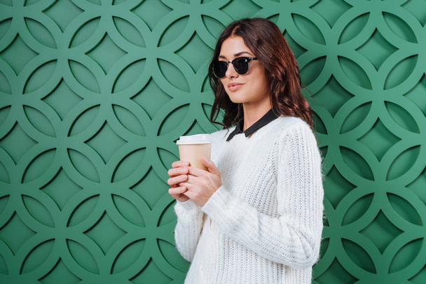 Женщина в солнечных очках с одноразовой чашкой кофе
 - Фото, изображение