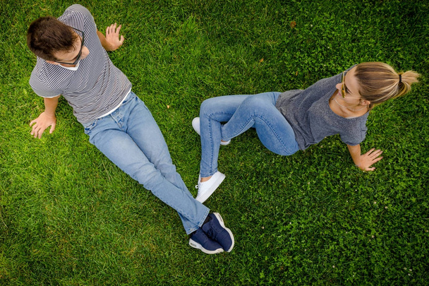Couple sitting on grass together - Foto, afbeelding