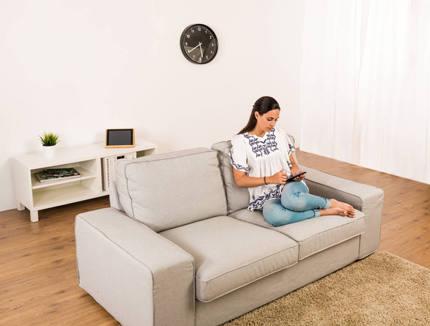 Woman sitting on couch - Foto, Bild