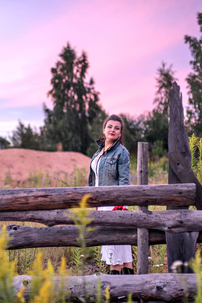 Late sunset at the countryside and cowgirl near a old wooden fence - Fotografie, Obrázek