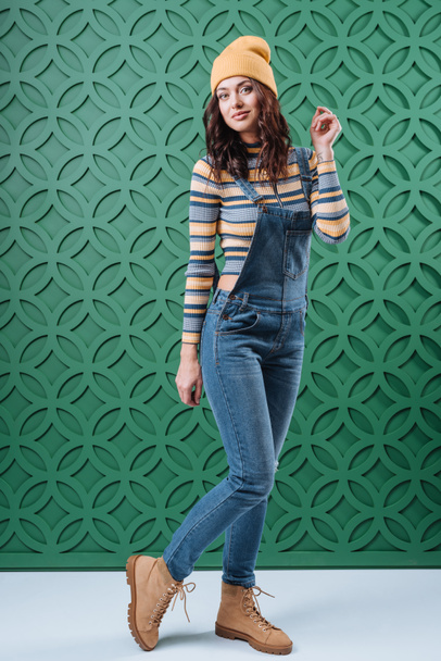 Woman posing in pullover, hat and overalls - Фото, изображение