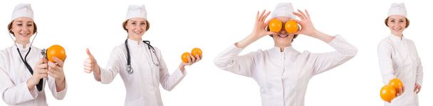 hübsche Ärztin hält Orange isoliert auf Weiß - Foto, Bild
