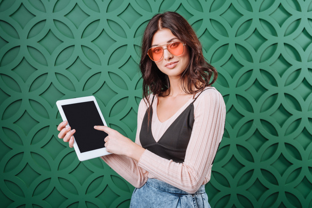 Γυναίκα με γυαλιά ηλίου που δείχνει στο υπολογιστή tablet   - Φωτογραφία, εικόνα