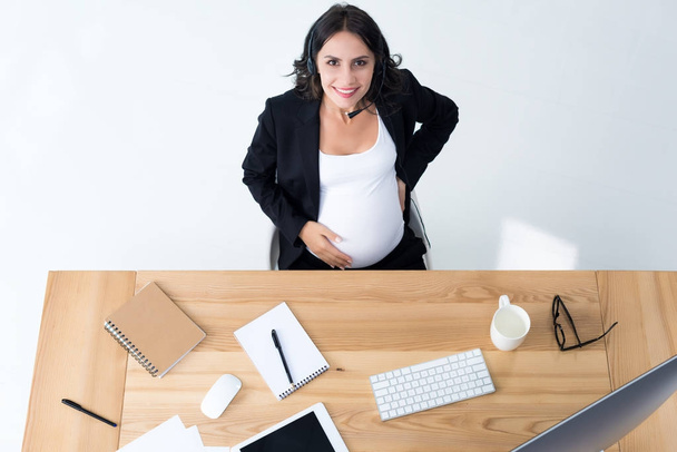 donna d'affari incinta con auricolare call center
 - Foto, immagini