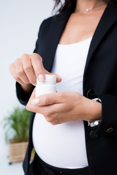 pregnant businesswoman with jar of pills - Foto, imagen