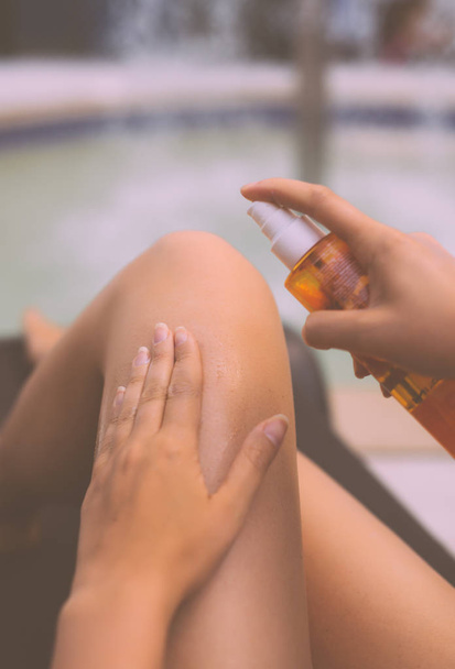 Woman applying sunblock cream on her legs. - Fotoğraf, Görsel