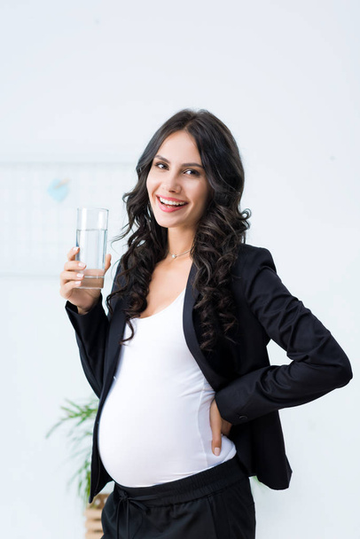 pregnant businesswoman with glass of water - Photo, Image
